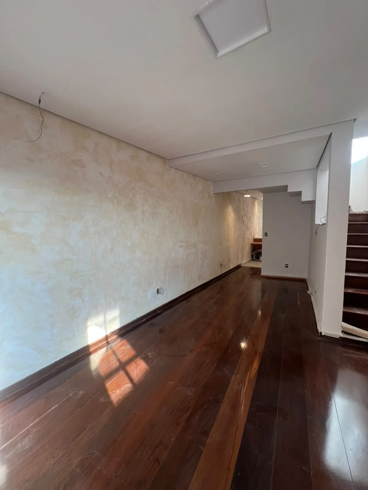 Hall de entrada finalizado com piso de madeira em obra em São Paulo